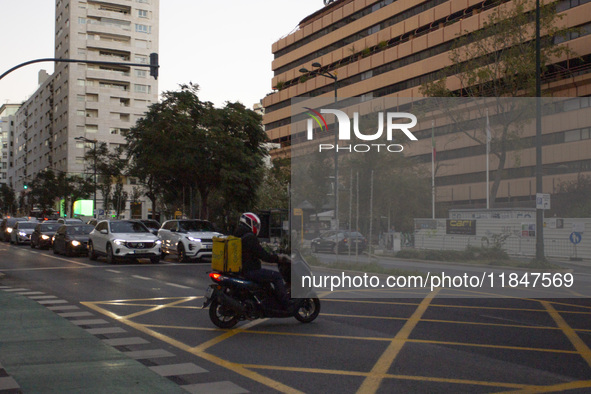 A food delivery person rides his motorbike in Lisbon, Portugal, on December 8, 2024. Glovo, the app-based food delivery service, hires its f...