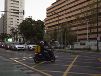 A food delivery person rides his motorbike in Lisbon, Portugal, on December 8, 2024. Glovo, the app-based food delivery service, hires its f...