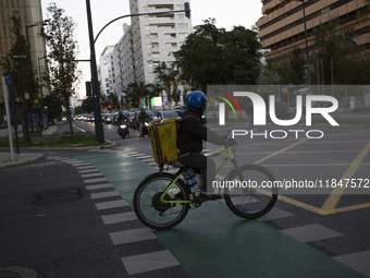 A food delivery person rides a bike in Lisbon, Portugal, on December 8, 2024. Glovo, the app-based food delivery service, hires its freelanc...