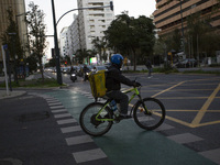 A food delivery person rides a bike in Lisbon, Portugal, on December 8, 2024. Glovo, the app-based food delivery service, hires its freelanc...