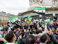 Members of the Syrian community and their supporters wave opposition flags as they gather in Paris on December 8, 2024, to celebrate the fal...