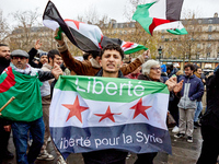 Members of the Syrian community and their supporters wave opposition flags as they gather in Paris on December 8, 2024, to celebrate the fal...