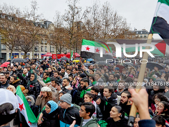 Members of the Syrian community and their supporters wave opposition flags as they gather in Paris on December 8, 2024, to celebrate the fal...