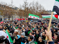 Members of the Syrian community and their supporters wave opposition flags as they gather in Paris on December 8, 2024, to celebrate the fal...