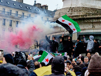 Members of the Syrian community and their supporters wave opposition flags as they gather in Paris on December 8, 2024, to celebrate the fal...