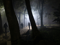 People walk through a park covered in light fog as winter begins in Dhaka, Bangladesh, on December 8, 2024. (