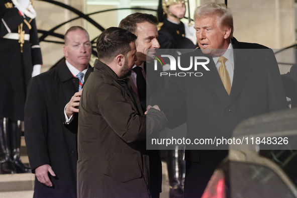 The United States President-elect Donald Trump and the Ukrainian President Volodymyr Zelensky shake hands in front of France's President Emm...