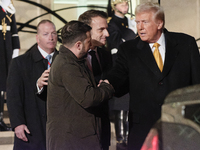 The United States President-elect Donald Trump and the Ukrainian President Volodymyr Zelensky shake hands in front of France's President Emm...