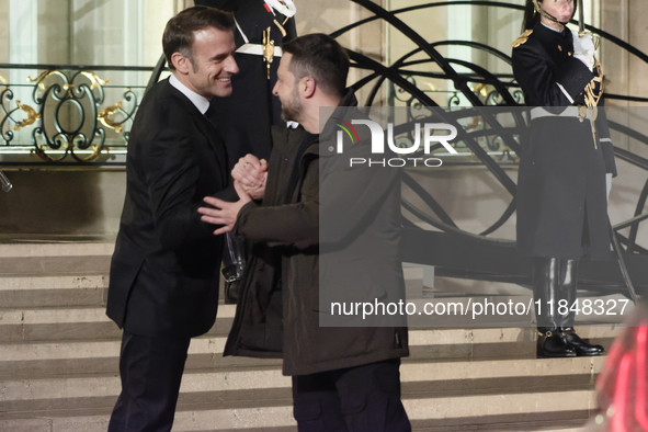 France's President Emmanuel Macron and Ukrainian President Volodymyr Zelensky shake hands in front of the steps of the Presidential Elysee P...