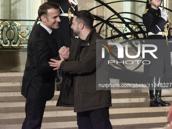 France's President Emmanuel Macron and Ukrainian President Volodymyr Zelensky shake hands in front of the steps of the Presidential Elysee P...