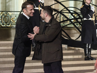 France's President Emmanuel Macron and Ukrainian President Volodymyr Zelensky shake hands in front of the steps of the Presidential Elysee P...