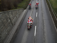 In Krakow, Poland, on December 8, 2024, motorcyclists in Santa costumes ride through the streets of the city to the University Children's Ho...