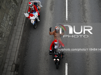 In Krakow, Poland, on December 8, 2024, motorcyclists in Santa costumes ride through the streets of the city to the University Children's Ho...