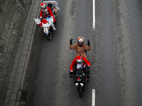 In Krakow, Poland, on December 8, 2024, motorcyclists in Santa costumes ride through the streets of the city to the University Children's Ho...