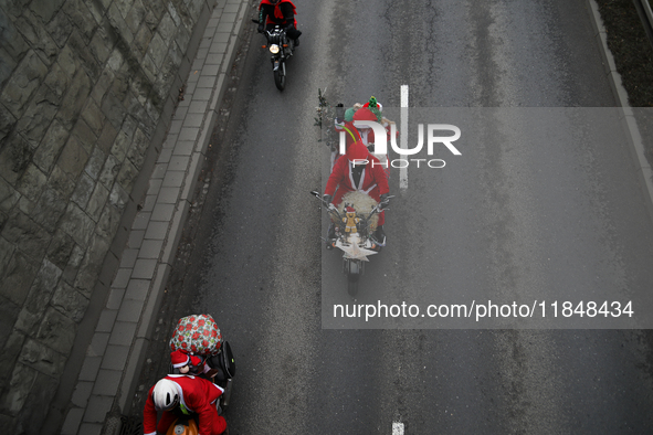 In Krakow, Poland, on December 8, 2024, motorcyclists in Santa costumes ride through the streets of the city to the University Children's Ho...