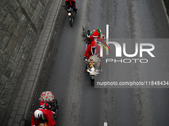 In Krakow, Poland, on December 8, 2024, motorcyclists in Santa costumes ride through the streets of the city to the University Children's Ho...