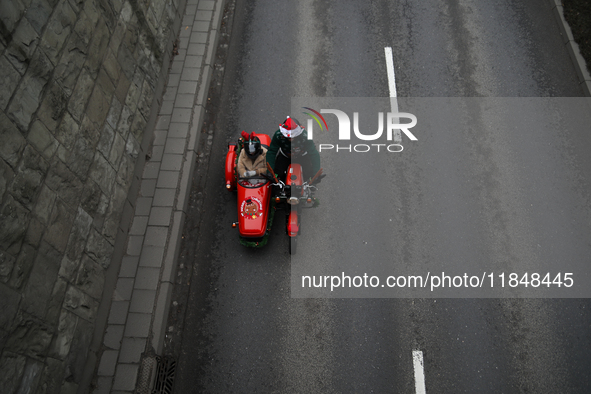 In Krakow, Poland, on December 8, 2024, motorcyclists in Santa costumes ride through the streets of the city to the University Children's Ho...