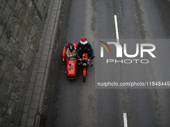 In Krakow, Poland, on December 8, 2024, motorcyclists in Santa costumes ride through the streets of the city to the University Children's Ho...