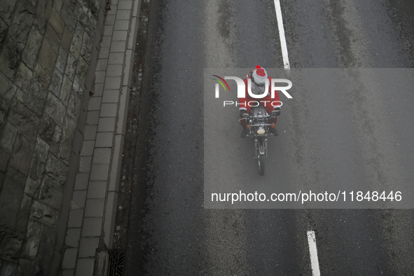 In Krakow, Poland, on December 8, 2024, motorcyclists in Santa costumes ride through the streets of the city to the University Children's Ho...