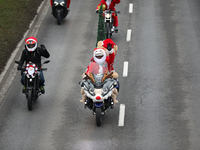 In Krakow, Poland, on December 8, 2024, motorcyclists in Santa costumes ride through the streets of the city to the University Children's Ho...