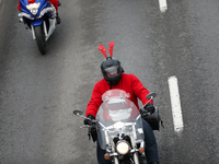 In Krakow, Poland, on December 8, 2024, motorcyclists in Santa costumes ride through the streets of the city to the University Children's Ho...