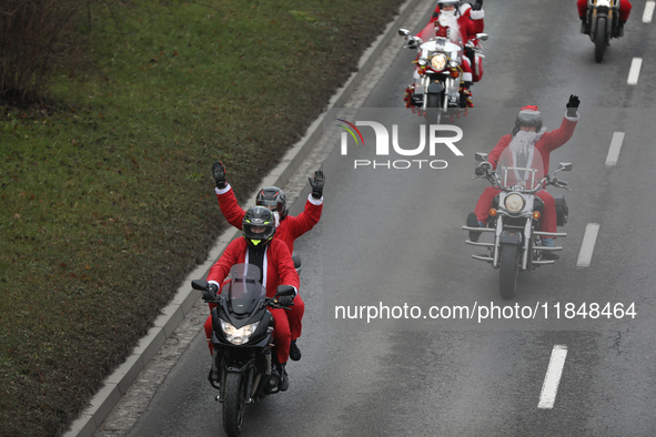 In Krakow, Poland, on December 8, 2024, motorcyclists in Santa costumes ride through the streets of the city to the University Children's Ho...