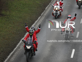 In Krakow, Poland, on December 8, 2024, motorcyclists in Santa costumes ride through the streets of the city to the University Children's Ho...