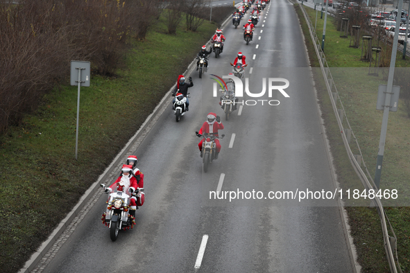 In Krakow, Poland, on December 8, 2024, motorcyclists in Santa costumes ride through the streets of the city to the University Children's Ho...