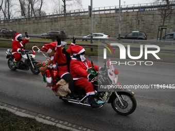 In Krakow, Poland, on December 8, 2024, motorcyclists in Santa costumes ride through the streets of the city to the University Children's Ho...