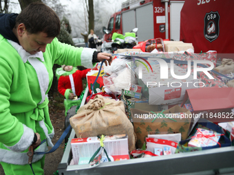 In Krakow, Poland, on December 8, 2024, motorcyclists in Santa costumes hand out gifts at the University Children's Hospital. Santas on moto...