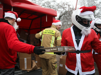 In Krakow, Poland, on December 8, 2024, motorcyclists in Santa costumes hand out gifts at the University Children's Hospital. Santas on moto...