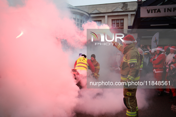 Motorcyclists in Santa costumes burn a tire on their motorcycle while handing out gifts at the University Children's Hospital in Krakow, Pol...