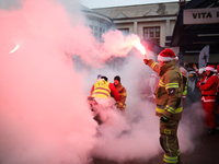 Motorcyclists in Santa costumes burn a tire on their motorcycle while handing out gifts at the University Children's Hospital in Krakow, Pol...