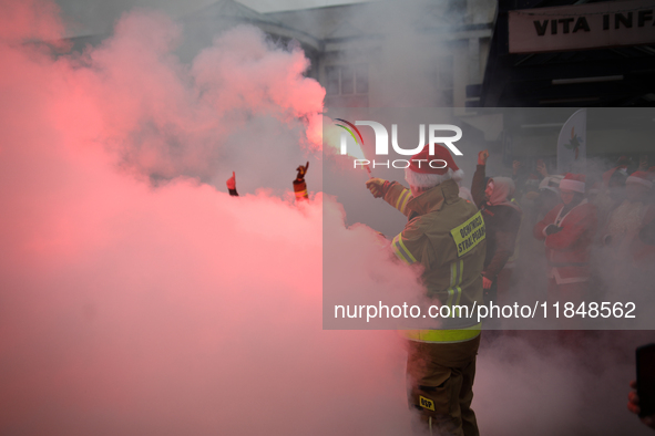 Motorcyclists in Santa costumes burn a tire on their motorcycle while handing out gifts at the University Children's Hospital in Krakow, Pol...