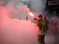 Motorcyclists in Santa costumes burn a tire on their motorcycle while handing out gifts at the University Children's Hospital in Krakow, Pol...