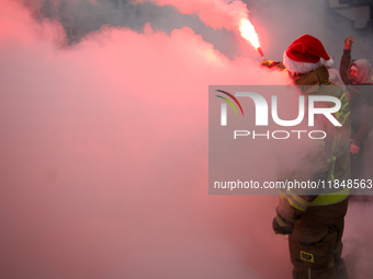 Motorcyclists in Santa costumes burn a tire on their motorcycle while handing out gifts at the University Children's Hospital in Krakow, Pol...