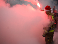 Motorcyclists in Santa costumes burn a tire on their motorcycle while handing out gifts at the University Children's Hospital in Krakow, Pol...