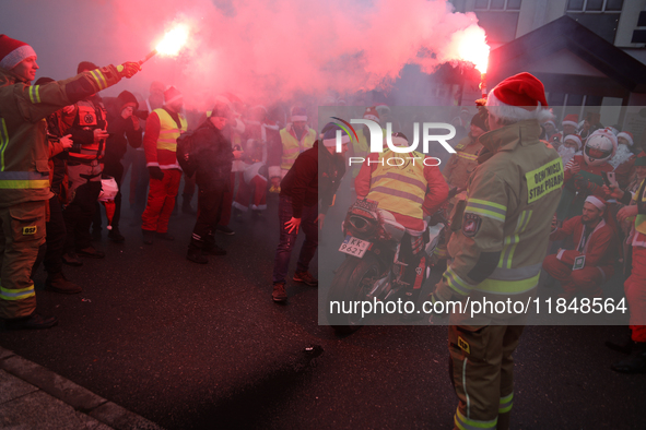 Motorcyclists in Santa costumes burn a tire on their motorcycle while handing out gifts at the University Children's Hospital in Krakow, Pol...