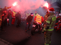 Motorcyclists in Santa costumes burn a tire on their motorcycle while handing out gifts at the University Children's Hospital in Krakow, Pol...