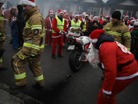 Motorcyclists in Santa costumes burn a tire on their motorcycle while handing out gifts at the University Children's Hospital in Krakow, Pol...