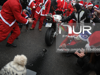 Motorcyclists in Santa costumes burn a tire on their motorcycle while handing out gifts at the University Children's Hospital in Krakow, Pol...