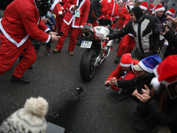 Motorcyclists in Santa costumes burn a tire on their motorcycle while handing out gifts at the University Children's Hospital in Krakow, Pol...