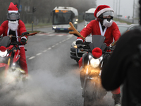 In Krakow, Poland, on December 8, 2024, motorcyclists in Santa costumes ride through the streets of the city to the University Children's Ho...