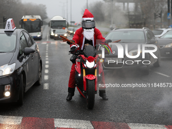 In Krakow, Poland, on December 8, 2024, motorcyclists in Santa costumes ride through the streets of the city to the University Children's Ho...