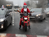 In Krakow, Poland, on December 8, 2024, motorcyclists in Santa costumes ride through the streets of the city to the University Children's Ho...