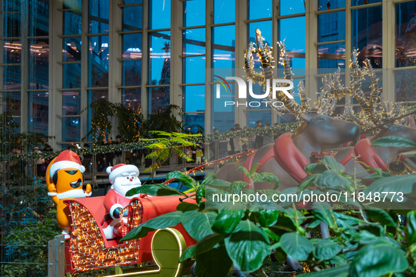 Visitors watch Santa Claus' flying sleigh ride at Halo Shopping Park in Chongqing, China, on December 8, 2024. 