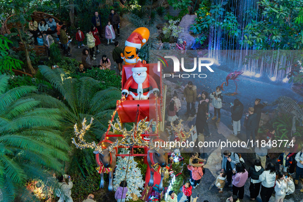 Visitors look at a Santa Claus installation at the Halo Shopping Park in Chongqing, China, on December 8, 2024. 