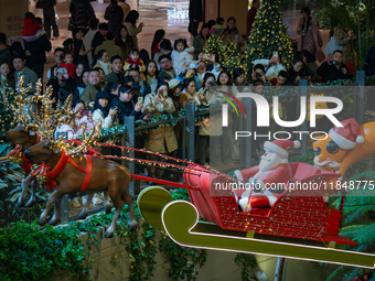 Visitors watch Santa Claus' flying sleigh ride at Halo Shopping Park in Chongqing, China, on December 8, 2024. (