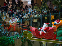 Visitors watch Santa Claus' flying sleigh ride at Halo Shopping Park in Chongqing, China, on December 8, 2024. (