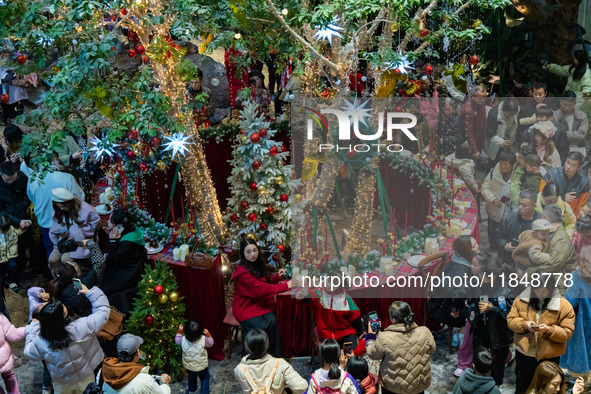 Visitors look at a Christmas tree installation at the Halo Shopping Park in Chongqing, China, on December 8, 2024. 